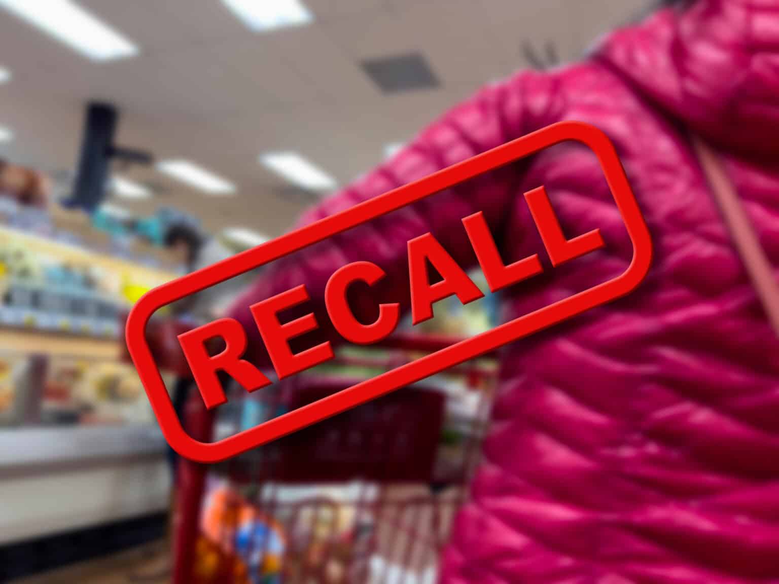 Blurry focus on a customer shopping inside a grocery store with the word Recall in the foreground